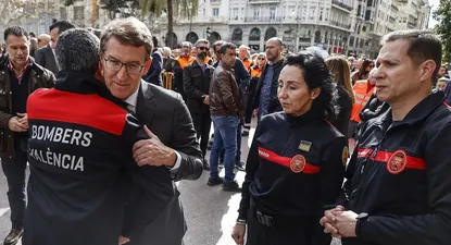 El presidente del Partido Popular, Alberto Núñez Feijóo, abraza a un bombero durante el minuto de silencio por las víctimas del incendio del barrio de Campanar.