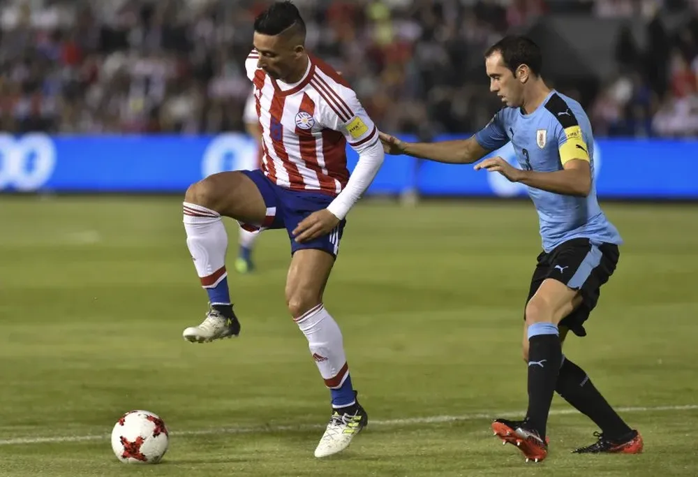 Lucas Barrios es marcado de cerca por Diego Godín