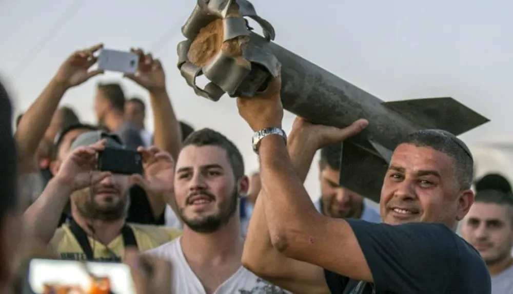 Israelíes muestran los restos de un cohete que cayó en Sderot.