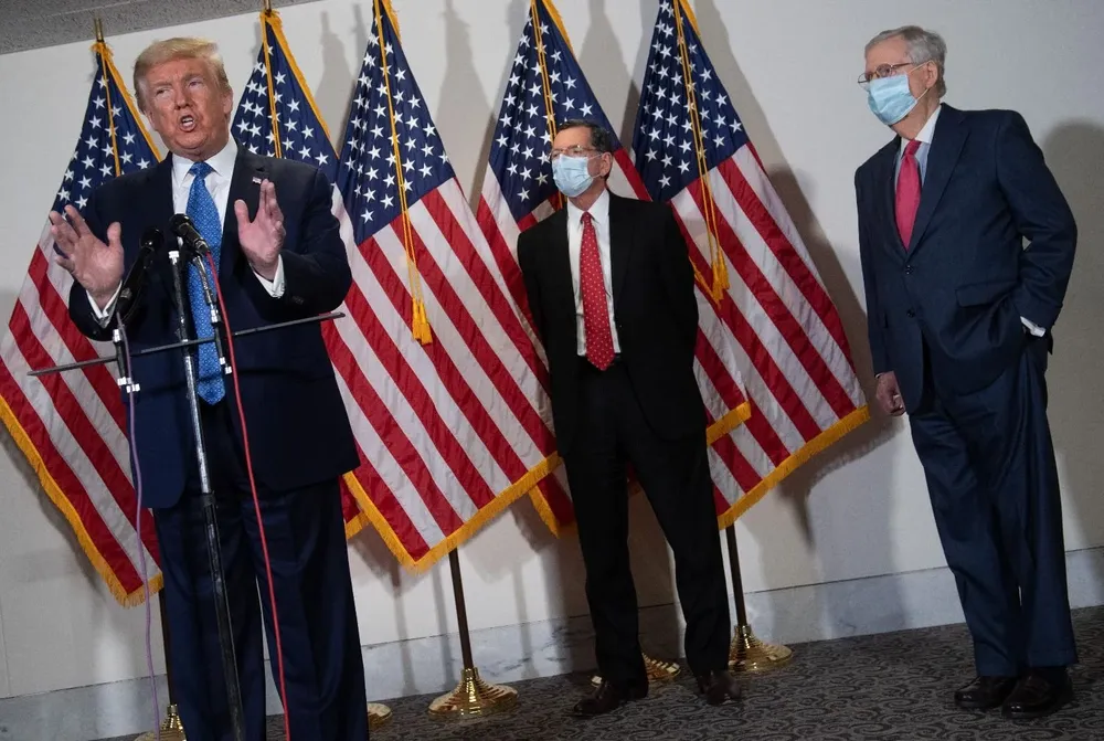 Donald Trump junto a Mitch McConnell y John Barrasso.