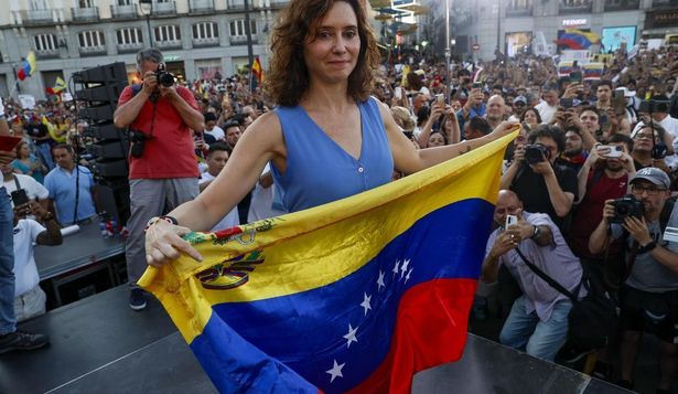 La presidenta de la comunidad de Madrid, Isabel Díaz Ayuso, sostiene una bandera de Venezuela