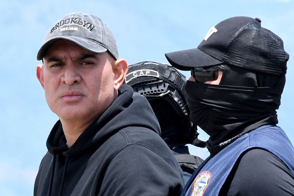 El presunto narcotraficante hondureño Mario José Calix, alias El Cubeta, es escoltado por miembros de la Dirección Nacional de Fuerzas Especiales (Cobras) durante su extradición a Estados Unidos en la base de Palmerola en Comayagua, a 50 km al norte de Tegucigalpa, el 4 de septiembre de 2024.