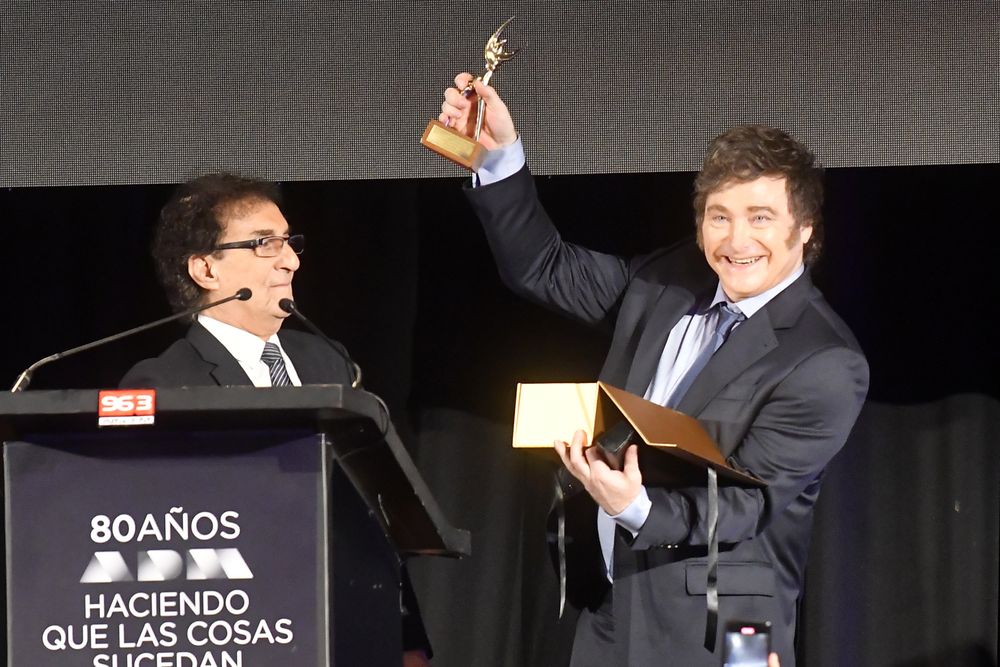 El presidente argentino Javier Milei recibe una distinción de manos del titular de la Asociación de Dirigentes de Marketing del Uruguay Jorge Abuchalja.