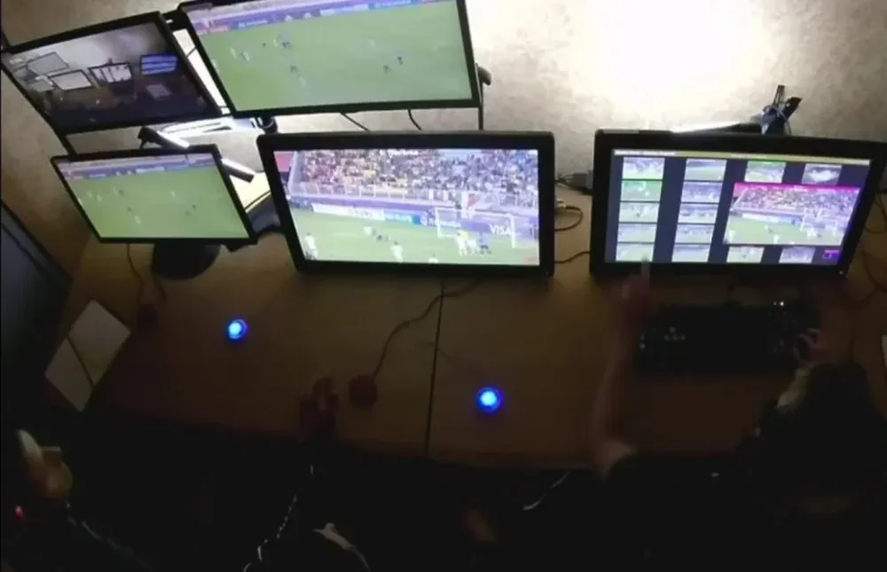 El árbitro asistente de video señala el monitor a la derecha de la imagen