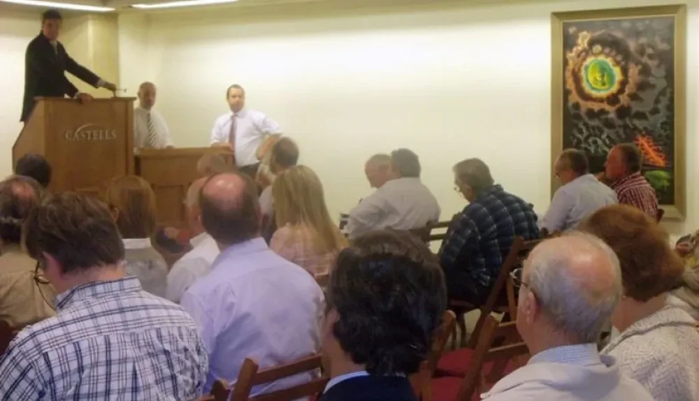 El rematador Juan Castells en el instante en que subasta la obra de José Cuneo