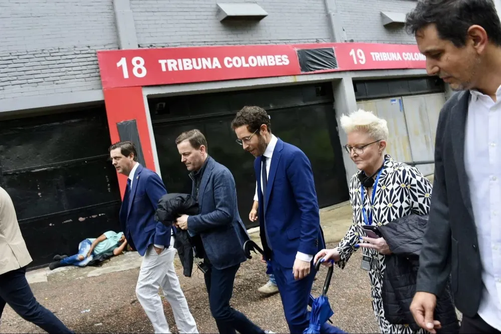 Ignacio Alonso y los visitantes de la FIFA recorren las afueras del Centenario, y un hombre en situaión de calle, duerme en el piso de la puerta 18 de la Tribuna Colombes
