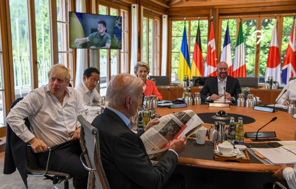 Joe Biden lee el diario en una mesa redonda, acompañado de otros líderes del G7