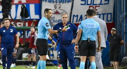 Esteban Ostojich entrega al encargado de seguridad una petaca que cayó desde la tribuna