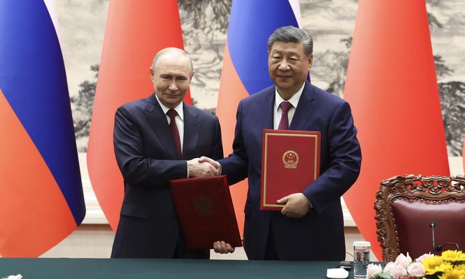 El presidente ruso Vladimir Putin (izquierda) y el presidente chino Xi Jinping (derecha) se dan la mano durante una ceremonia de firma en el Gran Salón del Pueblo en Pekín, China.