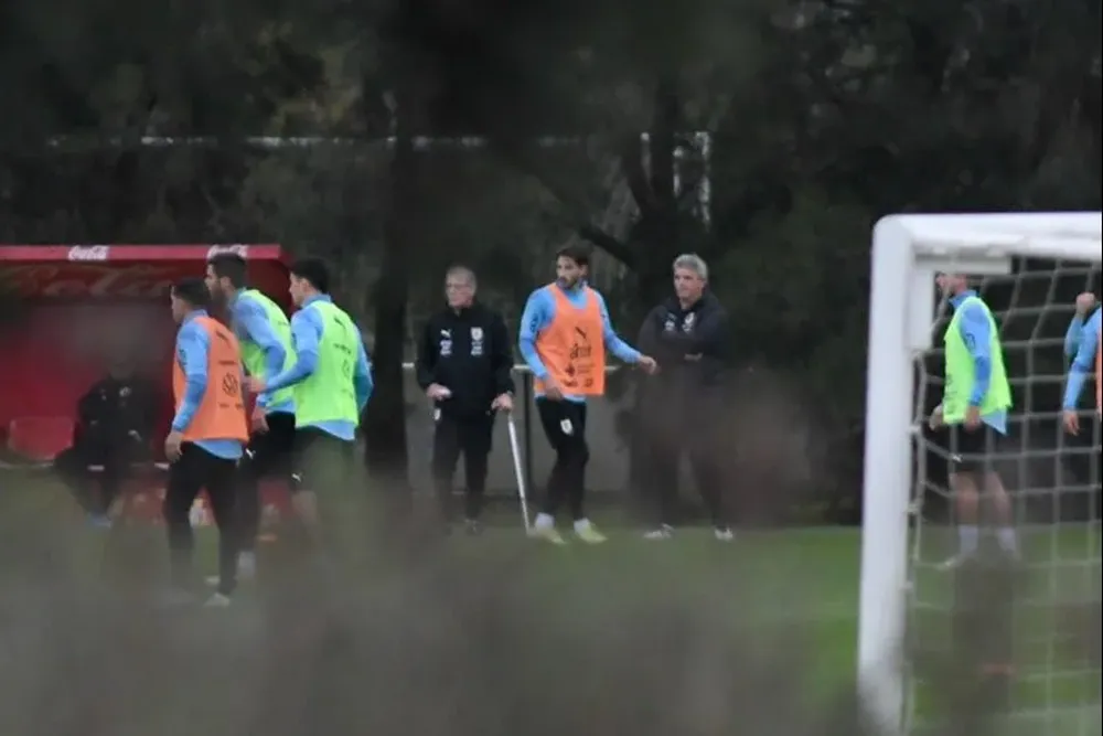 Viña con chaleco naranja y Bentancur de verde, mientras Tabárez observa el movimiento