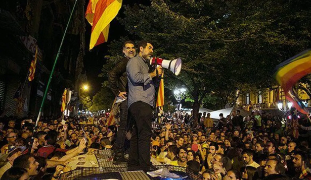 Los independentistas Sánchez y Cuixart, encima de un coche de la Guardia Civil durante los incidentes del 20 de septiembre de 2017.