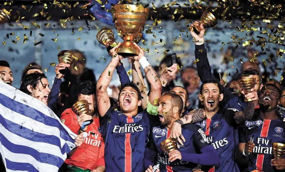 Cavani con la bandera uruguaya recibiendo la copa