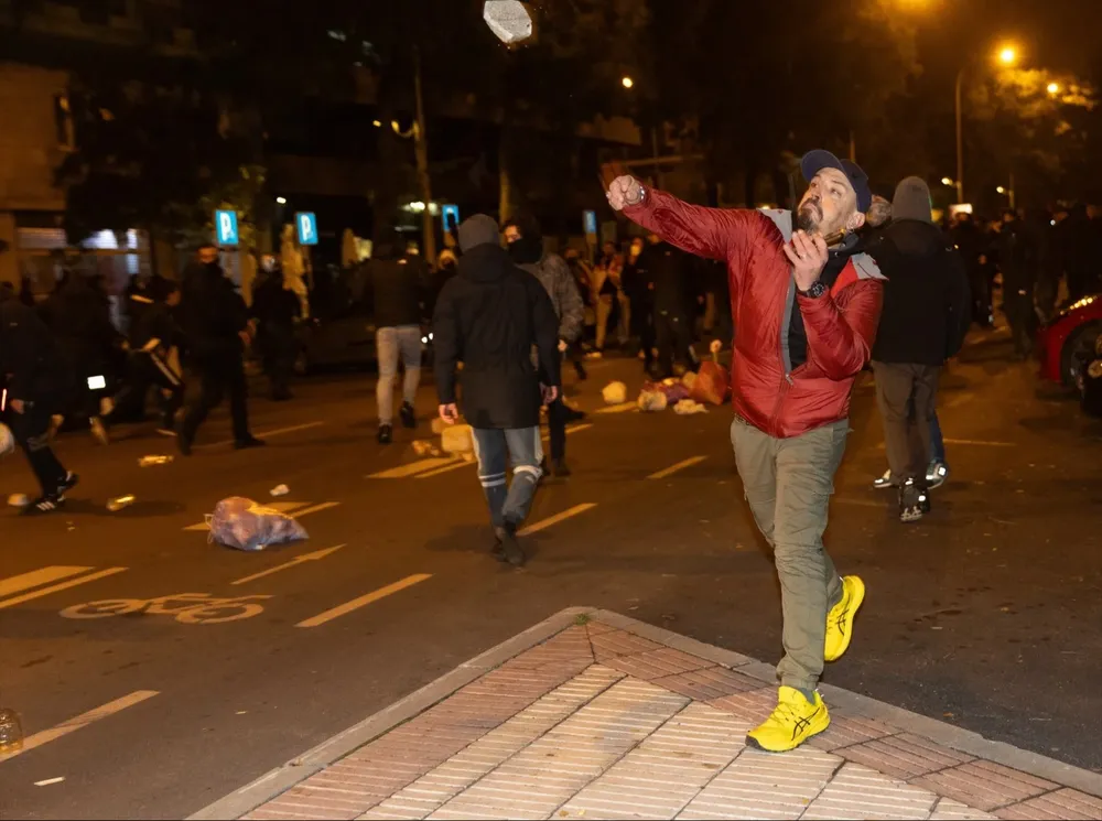Manifestante lanzando un trozo de adoquín, en la sede del PSOE en la calle Ferraz de Madrid