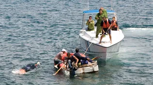 En esta imagen de archivo, guardacostas cubanos ordenan a los aspirantes a emigrados cubanos en un bote casero que regresen a la costa luego de que su intento de escapar de la isla fuera frustrado por las corrientes marinas