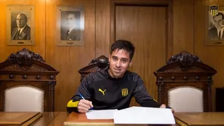 Óscar Cruz firmando contrato profesional en la sede de Peñarol