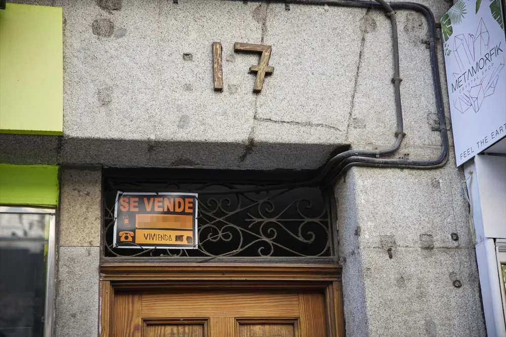 Cartel de una vivienda en venta en el escaparate en el barrio de Almagro.
