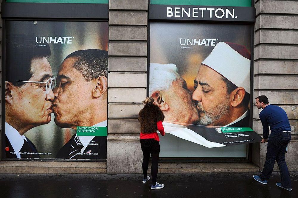 Empleados de Benetton retiran el cartel que muestra al papa Benedicto XVI besando al iman egipcio Ahmed el Tayyeb,  junto a otro cartel con el presidente estadounidense Barack Obama besando a su homólogo chino, Hu Jintao, en 2011.