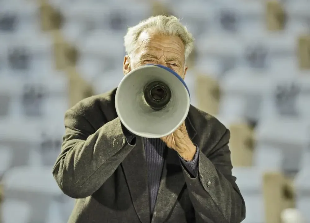 Con un cono de plástico cortado, el hincha de Liverpool alienta a su equipo contra Independiente, el jueves, por la Sudamericana