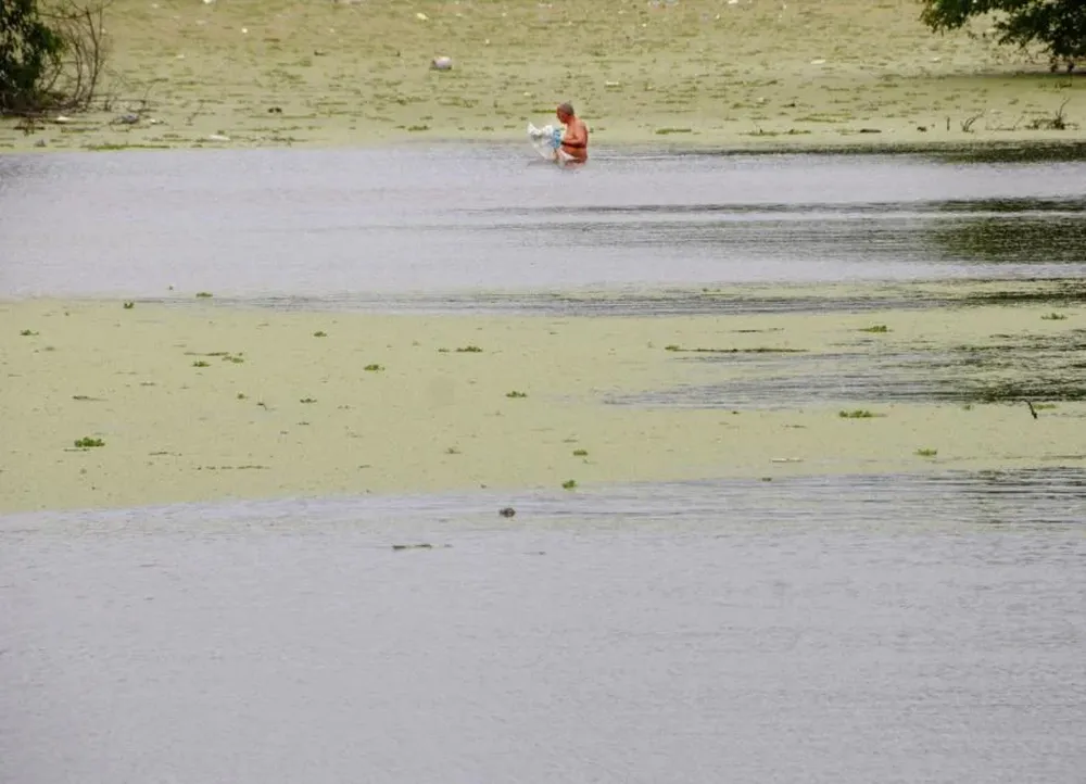 Un hombre pesca en un lago de Paso Carrasco, donde existe una elevada contaminación