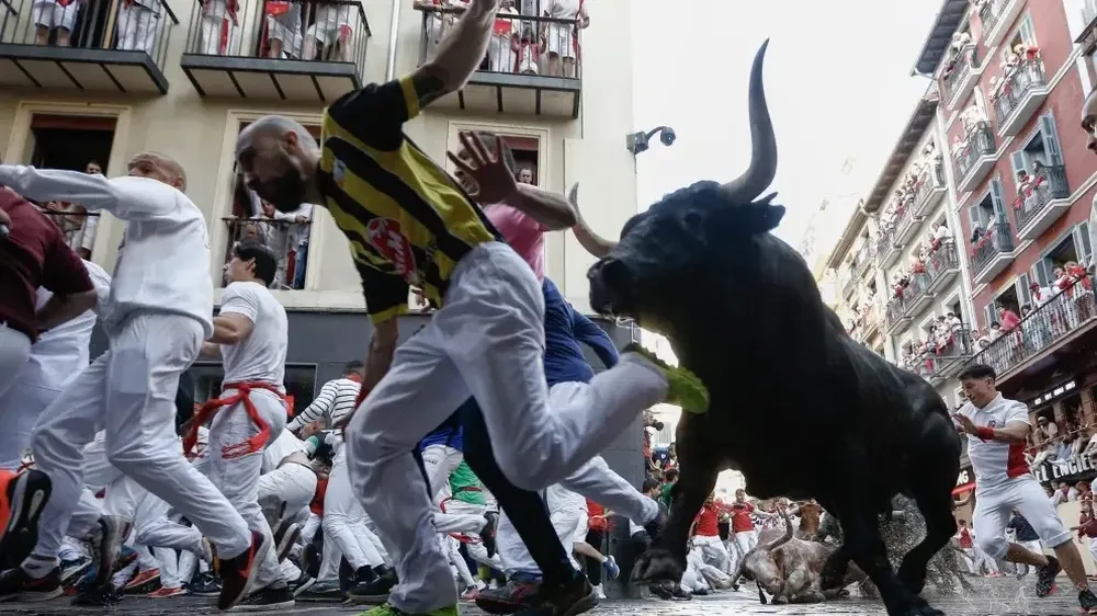 Uno de los que desafían a los toros tratando de escapar en Pamplona.