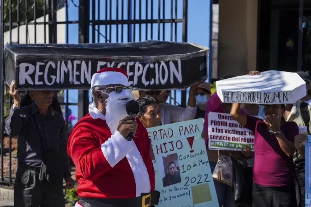 Un hombre disfrazado de Santa Claus marcha junto a familiares de detenidos bajo el régimen de excepción en El Salvador.