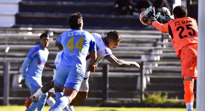 Francisco Tinaglini de Montevideo City Torque se queda con la pelota ante la llegada de Eduardo Vargas de Nacional por el Torneo Intermedio
