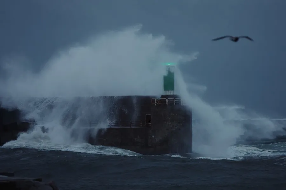 Una ola rompe contra el dique del puerto en A Guarda, Galicia.