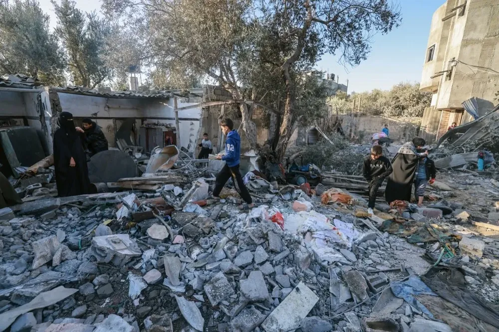 Habitantes de Rafah revisan los escombros de un edificio derribado por las bombas.