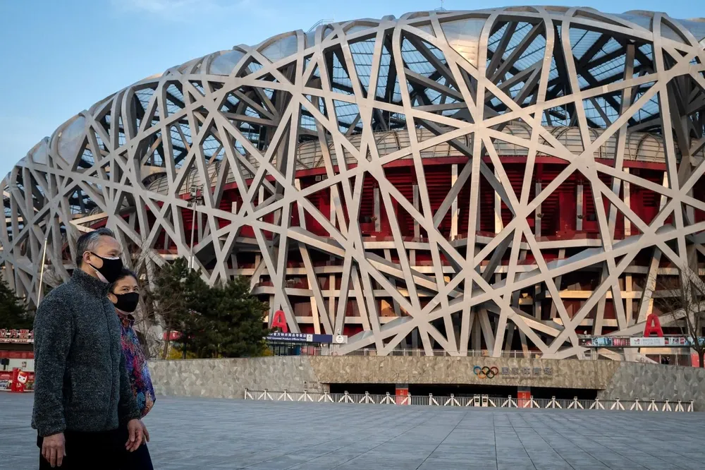 Ciudadanos chinos caminan cerca del estadio Nido de Pájaro