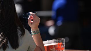 Una persona fumando en una terraza.