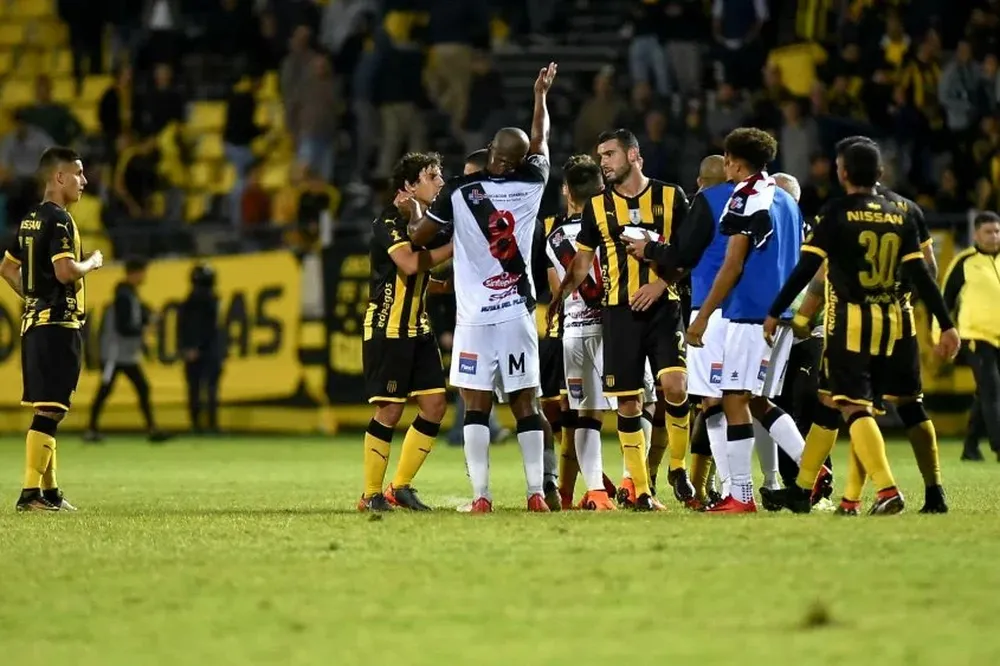 Peñarol-Danubio: Brian Rodríguez, a la izquierda en la foto, observa a distancia el forcejeo entre rivales