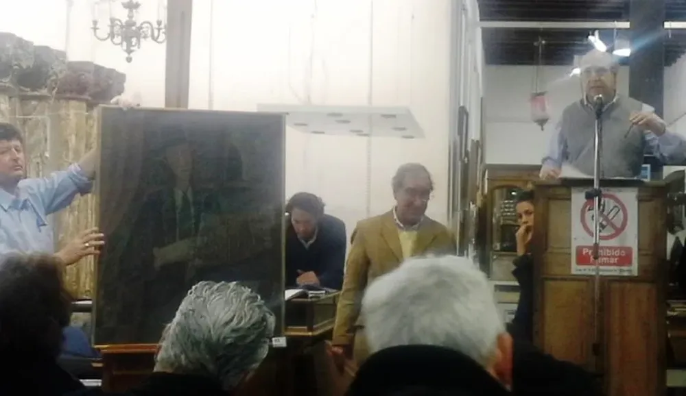 El rematador Héctor Bavastro escucha ofertas por una pintura del artista Juan Storm.