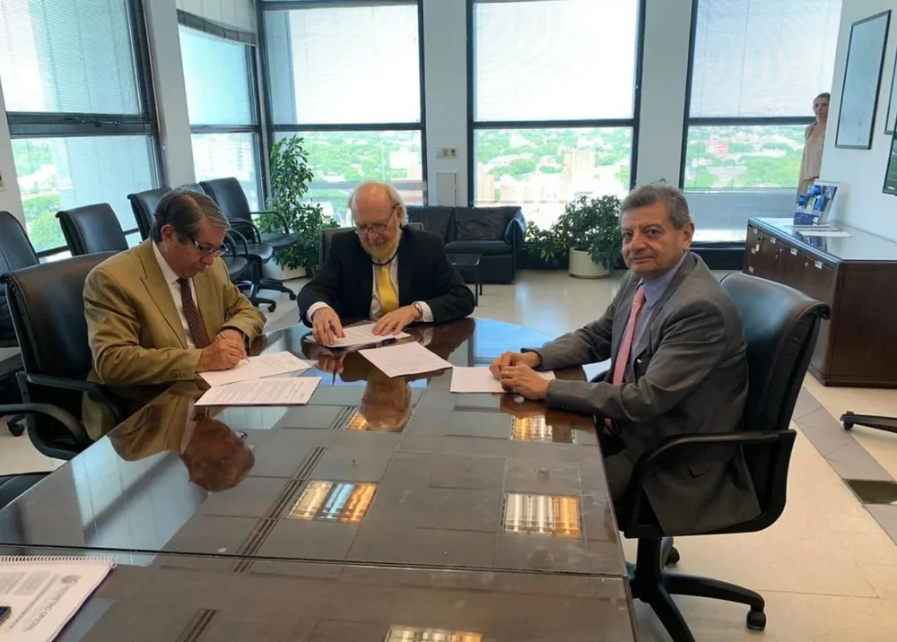 El gerente general de UTE Carlos Pombo y autoridades de Ecuador, durante la firma del convenio en Uruguay.