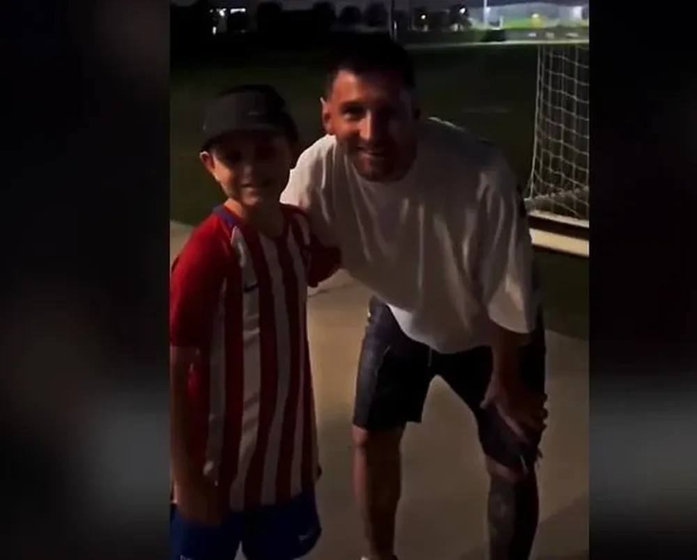 Luis Suárez y Lionel Messi con un niño del Atlético de Madrid