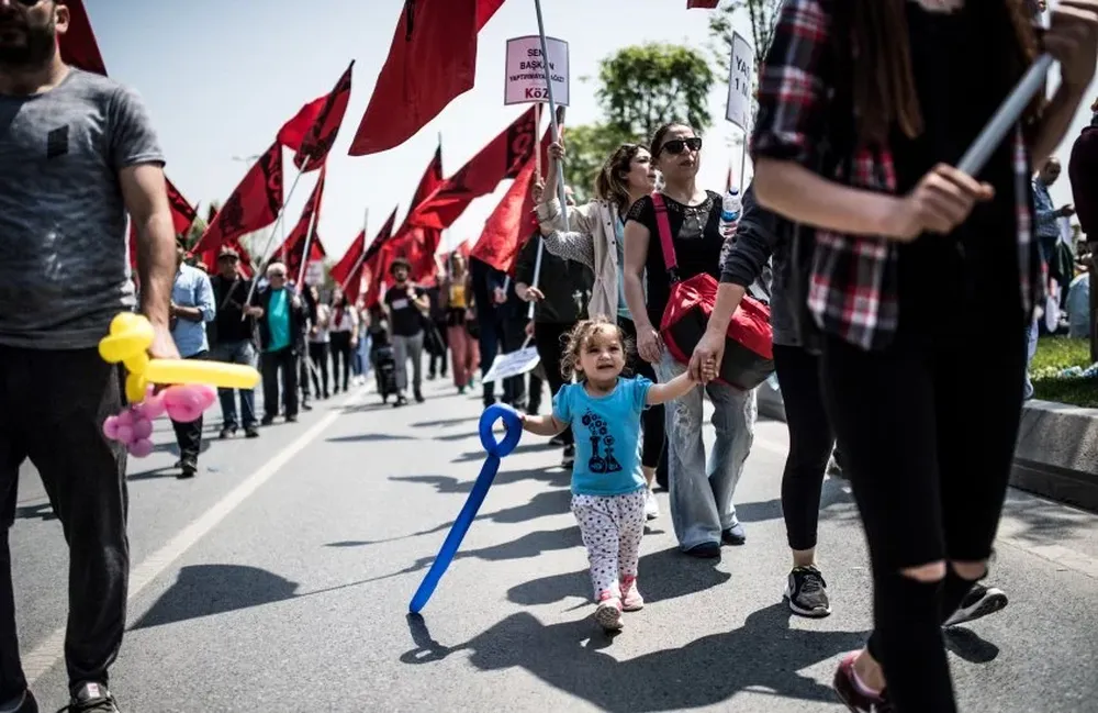 Una niña de la mano de una mujer en plena marcha del 1° de mayo, en Estambul (Turquía)