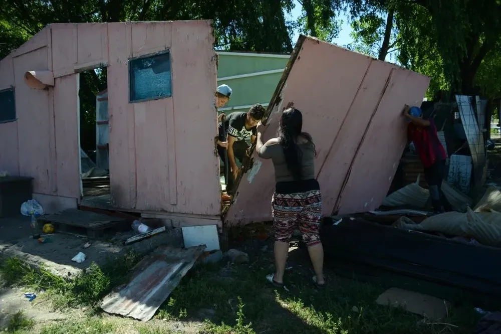 Mientras esperan por el camión que los llevará a su nueva vivienda, los vecinos de Isla de Gaspar desarman sus viejos ranchos.