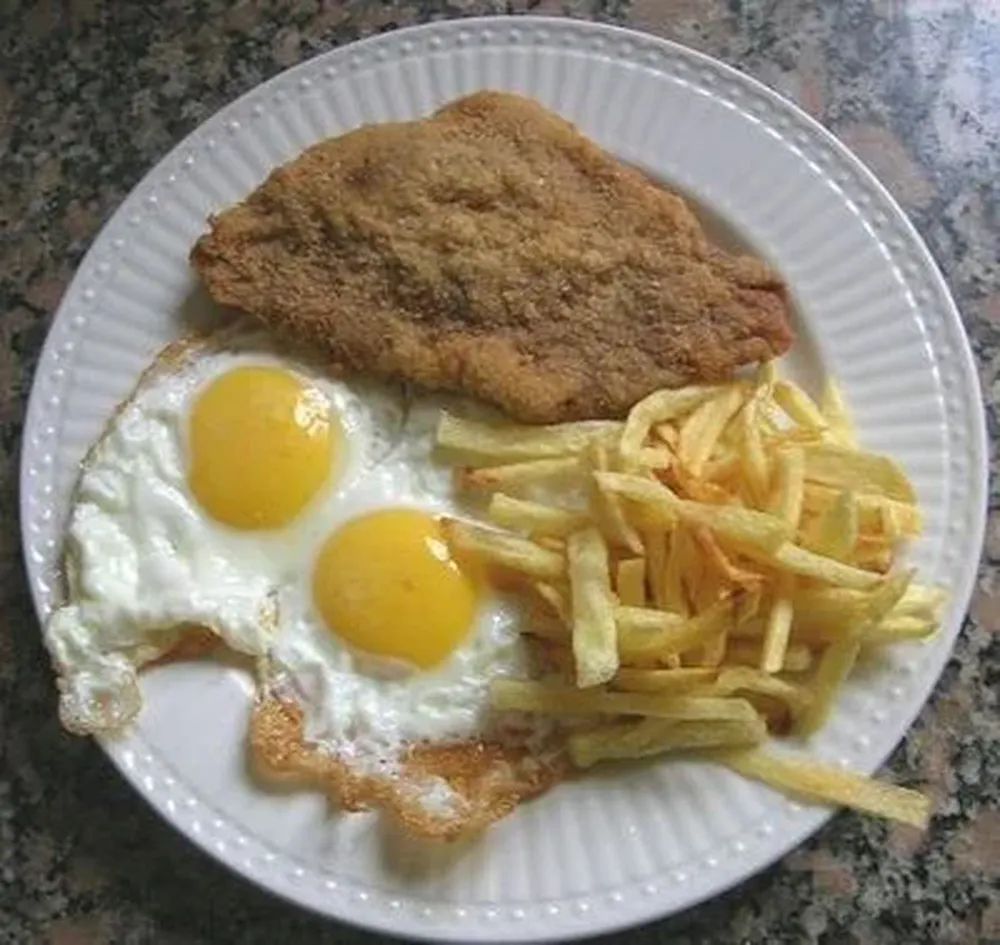 Milanesa con papas fritas y huevo frito