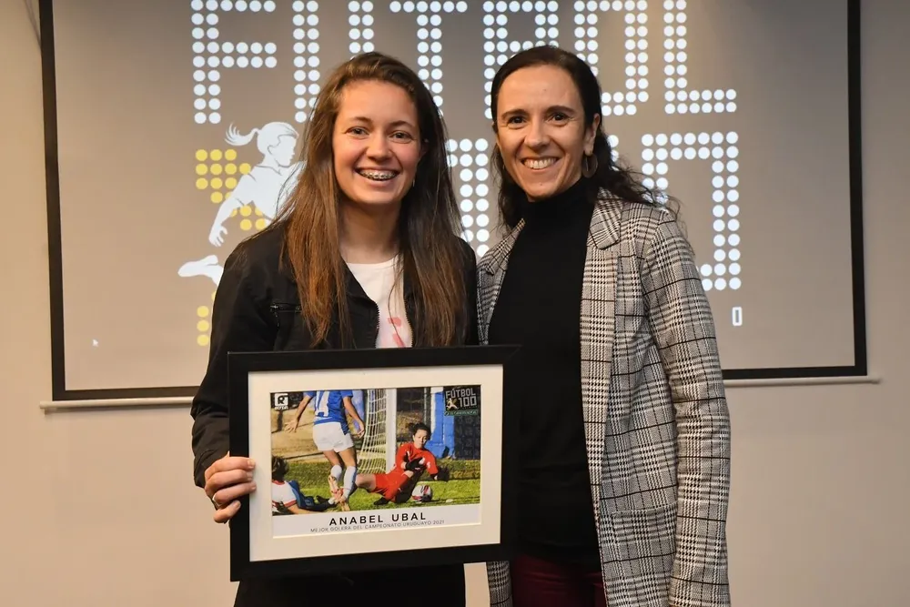 Anabel Ubal recibe el premio de manos de Natalia Roba, editora jefa de El Observador