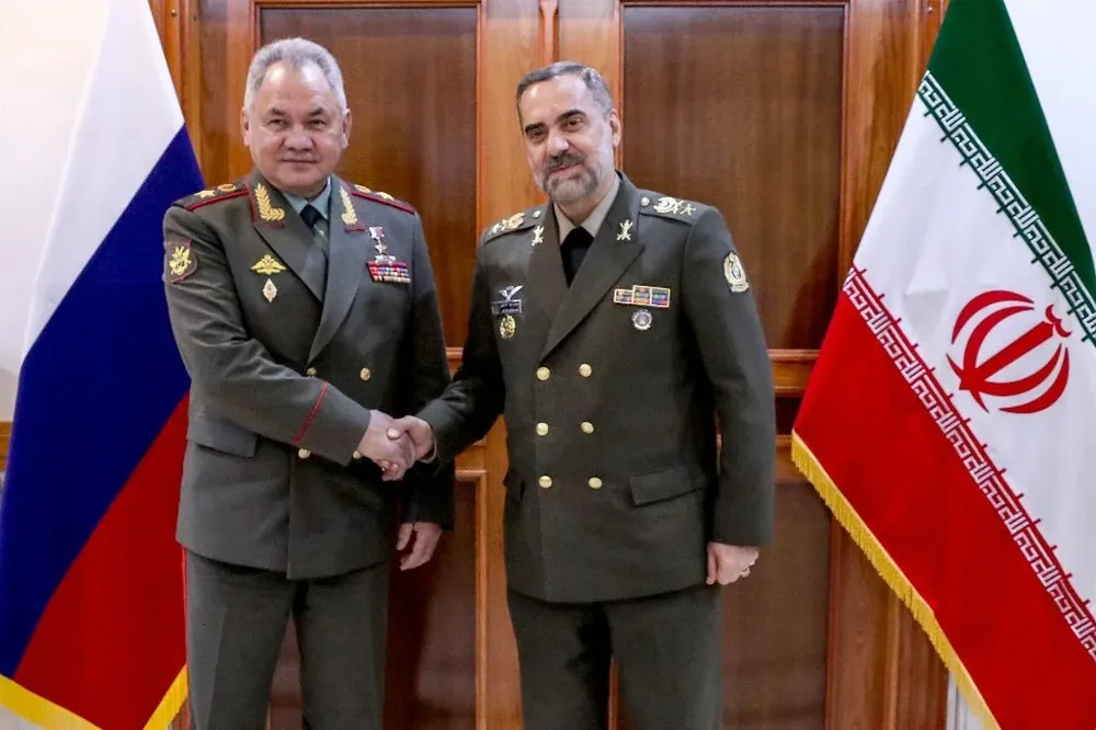 El ministro de Defensa iraní Mohammad-Reza Gharaei Ashtiani (Der.) recibe a su par ruso, Serguei Shoigu (Izq.) durante su visita a Teherán.