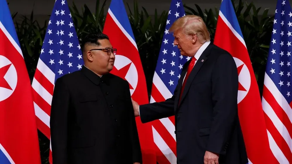 Trump guía ligeramente a Kim para salir de la alfombra roja y dirigirse a la siguiente estancia.