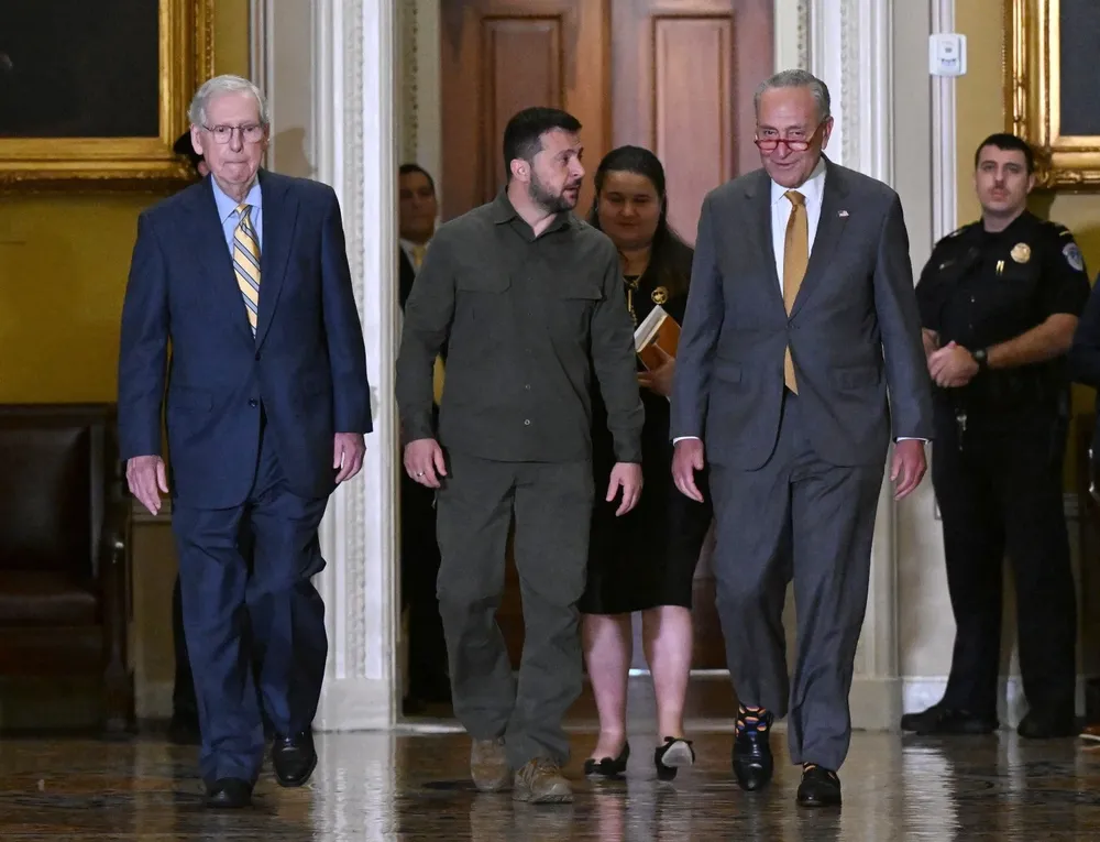 El presidente de Ucrania, Volodymyr Zelensky (centro), entra al Capitolio con el líder de la minoría del Senado, Mitch McConnell (izqu,) y el líder de la mayoría del Senado, Chuck Schumer (der.)