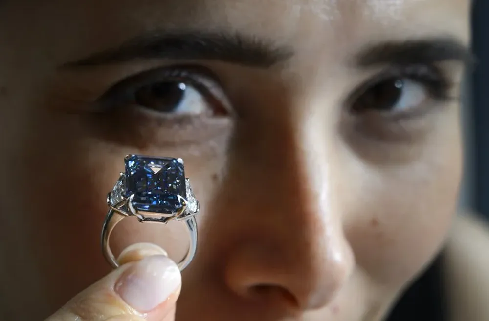 Una mujer sostiene el Opphenheimer Blue, un diamante extraño azul en Suiza.