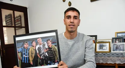 Lucas con un cuadro de sus grandes trofeos: la Supercopa Uruguaya, su madre y sus abuelos