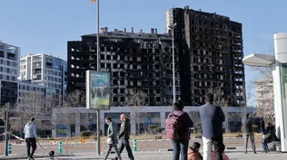 Varias personas observan esta mañana de sábado el edificio incendiado en el barrio de Campanar de València. La policía científica y judicial ha localizado este sábado por la mañana un nuevo cuerpo lo que eleva a 10 el total de víctimas mortales de este siniestro.