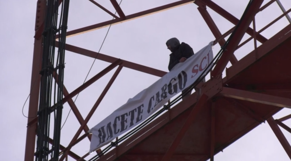 El hombre que trepó a la torre de Antel en Florida y su pancarta