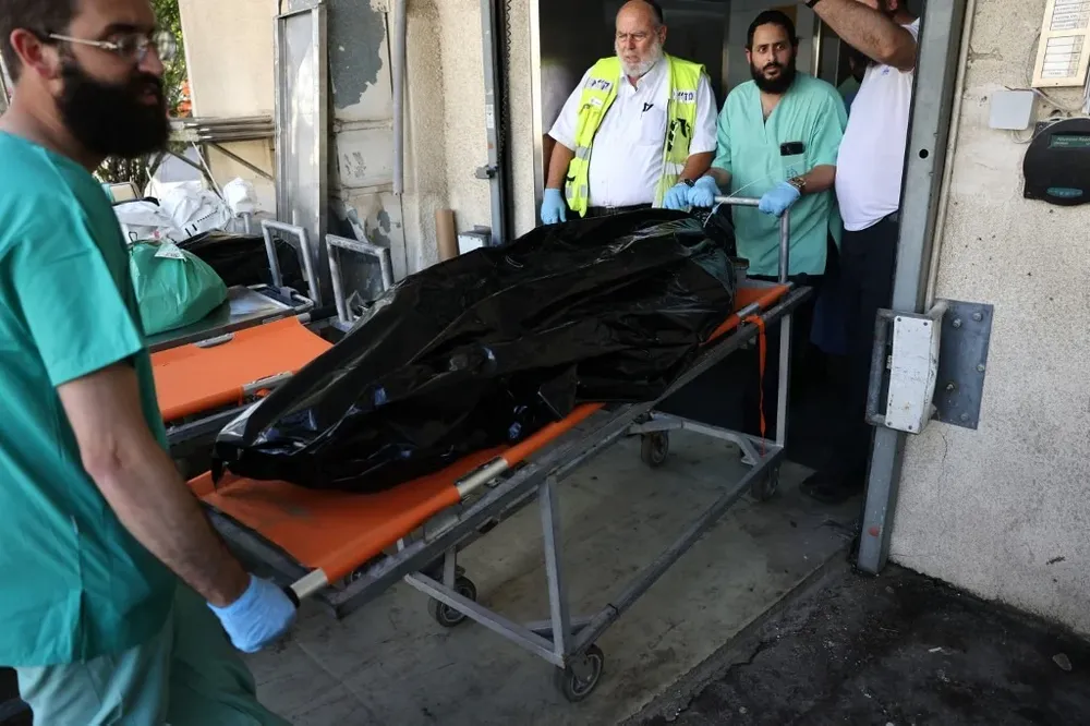 Personal del Centro Nacional de Medicina forense de Israel trasladan el cuerpo de una víctima de los ataques de Hamás.