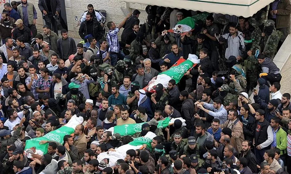 Varias personas llevan a hombros los cadáveres de varios militantes de Hamas en Al Moghraqa, Gaza