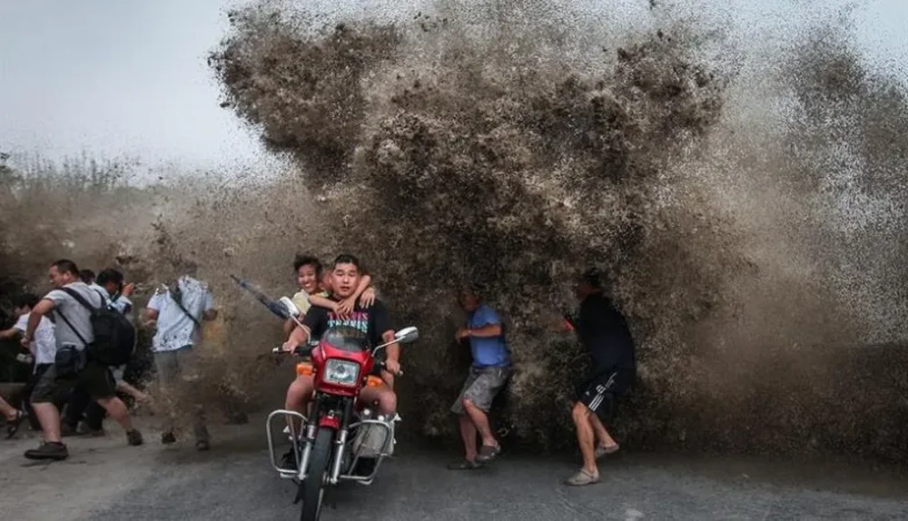 China. Un grupo de personas huye de una fuerte ola del río Qiantang, en Hangzhou