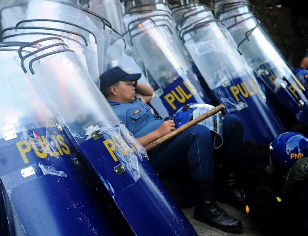 FILIPINAS. Policía duerme entre escudos anti-disturbios antes de bloquear a los manifestantes.