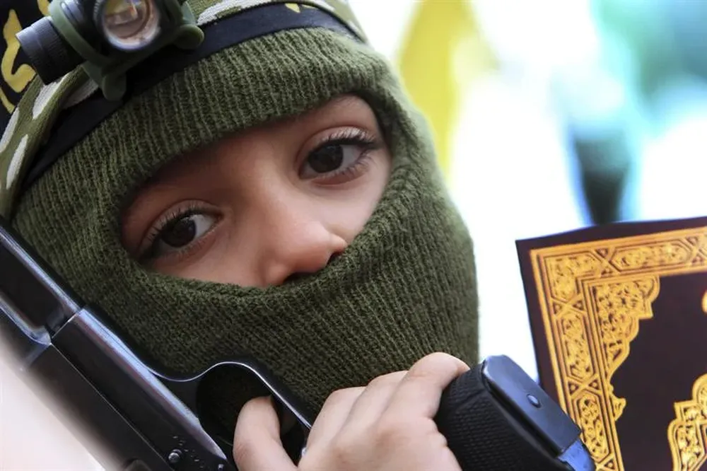 Líbano- Un niño con una copia del Corán y una pistola participa en una manifestación pro palestinos